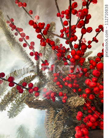 a bouquet of branches with red berries and fir branches in smoke in sunny weather, the rays of the sun through the branches a bouquet of branches with red berries and fir branches in smoke in sunny weather, the rays of the sun through the branches 112710838