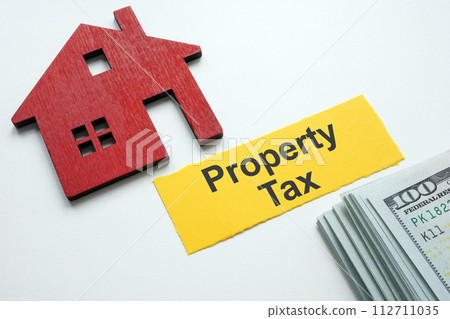A strip of paper property tax, a model of a house and money. 112711035