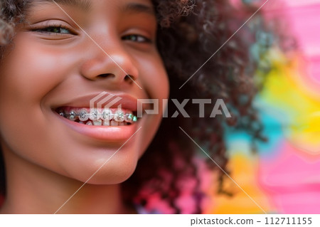 AI-generated content. Vibrant close-up of a cheerful young girl showing off her braces, with a colorful abstract background. 112711155