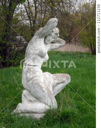 Old statue of woman after swimming in the park. Soviet monumental sculpture 112711236