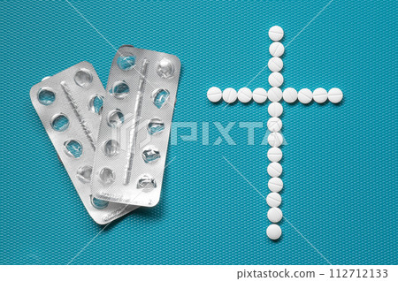 empty packages from taken pills and a grave cross laid out of small white tablets as a symbol of death from an overdose of drugs or abuse of medical drugs and uncontrolled self-medication. empty packages from taken pills and a grave cross laid out of small white tablets as a symbol of death from an overdose of drugs or abuse of medical drugs and uncontrolled self-medication. 112712133