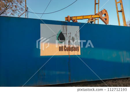 Blank sign from unknown oil company that is splattered with oil and dripping from its surface. Symbol of soiling, compromise, and difficult mining conditions that lead to various dangerous situations 112712193