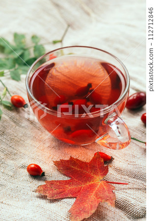 A cup of rose hip tea with fresh berries in a glass cup. Vintage background, selective focus 112712846