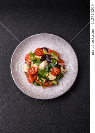 Delicious fresh caprese salad with mozzarella, tomatoes, greens with salt, spices and herbs Delicious fresh caprese salad with mozzarella, tomatoes, greens with salt, spices and herbs 112713209