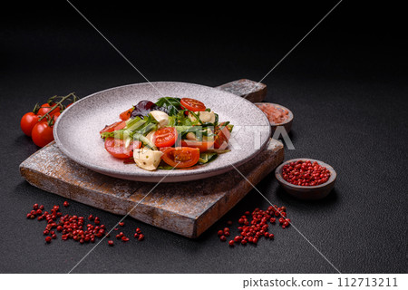 Delicious fresh caprese salad with mozzarella, tomatoes, greens with salt, spices and herbs Delicious fresh caprese salad with mozzarella, tomatoes, greens with salt, spices and herbs 112713211