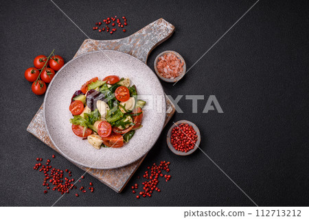 Delicious fresh caprese salad with mozzarella, tomatoes, greens with salt, spices and herbs 112713212