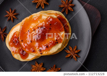Fresh baked pancakes with delicious jam on a ceramic plate 112713228