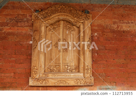 Homemade wooden sashes on a window in a traditional Balinese house. 112713955