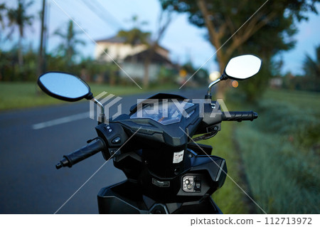 The foggy mirror and the speedometer on the scooter are covered with morning dew. The foggy mirror and the speedometer on the scooter are covered with morning dew. 112713972