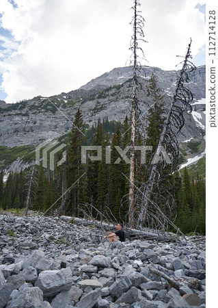 A man sits in a rocking-egg in a straw pergola enjoying the sunset A man sits in a rocking-egg in a straw pergola enjoying the sunset 112714128