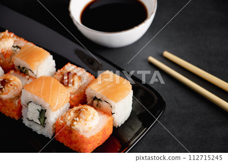 Set of sushi roll on black plate. Serving Japanese food in restaurant. Set of sushi roll on black plate. Serving Japanese food in restaurant. 112715245