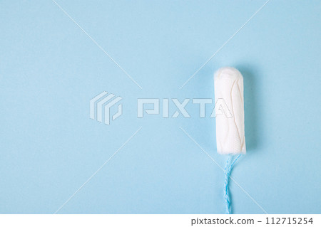 Hygienic cotton tampon on blue background. Feminine menstrual hygiene products. 112715254