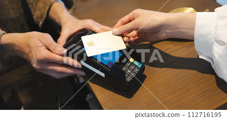 Hand paying by credit card at a store 112716195