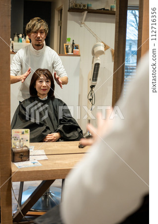 A woman getting her hair done at a beauty salon A woman getting her hair done at a beauty salon 112716356