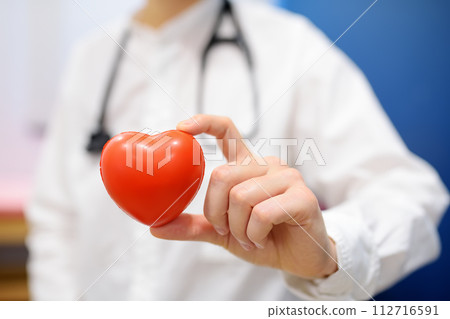 Female cardiologist holding red heart. Cardiology concept. Female cardiologist holding red heart. Cardiology concept. 112716591