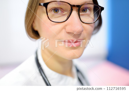 Close up portrait of young female doctor cardiologist during appointment of patient. Cardiology consultation and treatment of heart diseases Close up portrait of young female doctor cardiologist during appointment of patient. Cardiology consultation and treatment of heart diseases 112716595