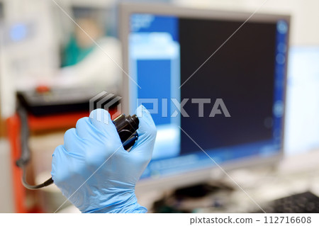 Radiologist is going to take X ray of patient in X-ray room of modern clinic. Close up photo of doctor hand presses button for execute of medical examination Radiologist is going to take X ray of patient in X-ray room of modern clinic. Close up photo of doctor hand presses button for execute of medical examination 112716608