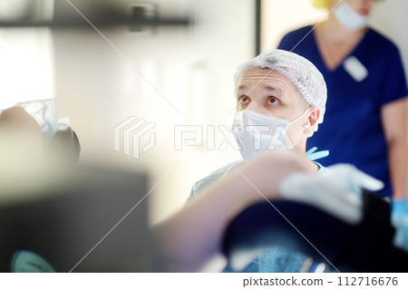 Gynecologist operation patient in gynecological chair. Doctor performs invasive medical procedure in modern hospital. Diagnosis and treatment of cervical cancer. Surgical removal of uterine cyst Gynecologist operation patient in gynecological chair. Doctor performs invasive medical procedure in modern hospital. Diagnosis and treatment of cervical cancer. Surgical removal of uterine cyst 112716676