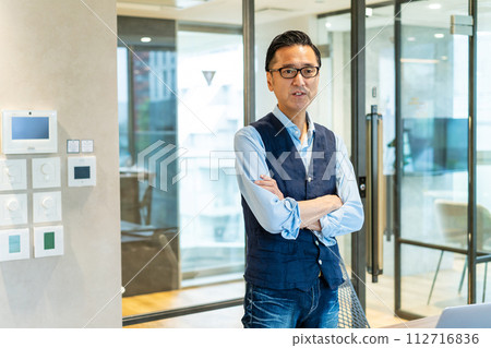 Smiling middle-aged man with arms folded, office casual 112716836
