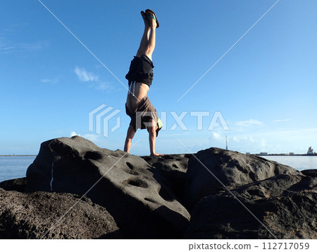 Man Handstands on rock jetty in Kahului Harbor 112717059