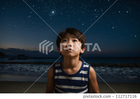 A boy looking up at the starry sky on the beach at night - AI-generated image 112717116