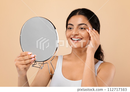 Facial Care. Attractive Indian Woman Looking At Magnifying Mirror And Touching Face 112717383