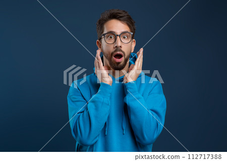 Portrait Of Shocked Young Man Opening Mouth And Looking At Camera 112717388