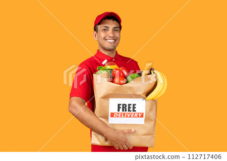 delivery worker guy holds paper food bag over yellow background 112717406