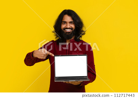 Positive indian man pointing at laptop with white screen 112717443