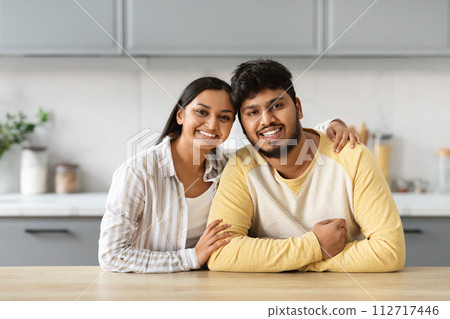 Portrait of loving young indian couple posing together at kitchen Portrait of loving young indian couple posing together at kitchen 112717446