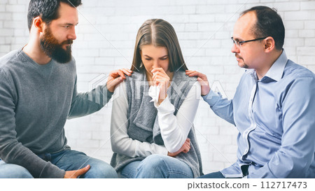 Group members supporting upset woman domestic violence victim on therapy session Group members supporting upset woman domestic violence victim on therapy session 112717473