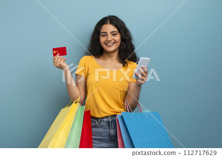 Smiling woman with credit card and phone 112717629