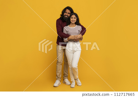 Couple hugging on bright yellow background Couple hugging on bright yellow background 112717665