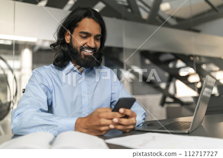 Professional checking smartphone with a smile 112717727