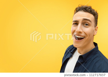 Closeup of funny young guy posing over yellow background Closeup of funny young guy posing over yellow background 112717837