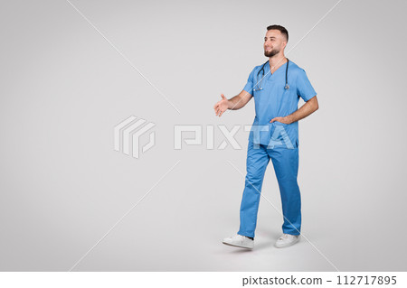 Young caucasian doctor man walking on grey background, full length, free space 112717895