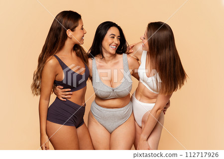 Three latin, arab, european joyful women in casual sportswear share light-hearted moment 112717926