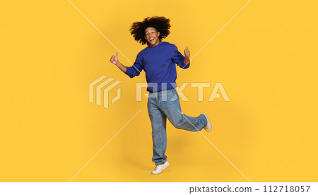 Joyful Young Black Man Jumping And Showing Thumbs Up At Camera 112718057