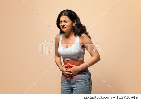 Sick indian woman having stomach ache, touching abdomen with red inflamed zone Sick indian woman having stomach ache, touching abdomen with red inflamed zone 112718449