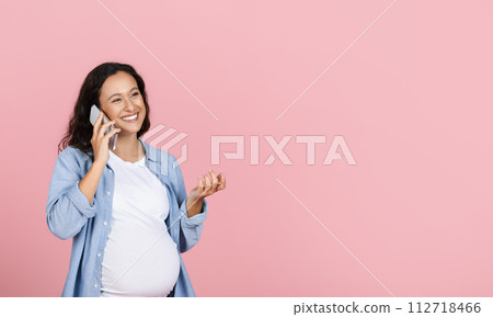 Happy pregnant woman talking to her expecting friend on phone Happy pregnant woman talking to her expecting friend on phone 112718466