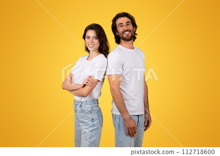 Side-by-side, a confident woman and a beaming man stand back-to-back 112718600