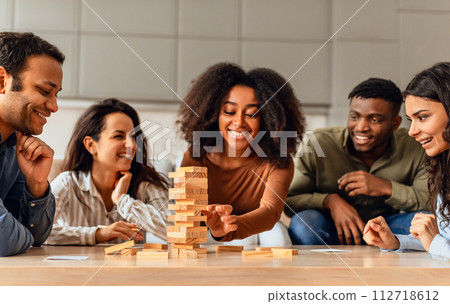 students group around table in kitchen engaging in board game students group around table in kitchen engaging in board game 112718612
