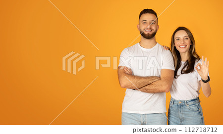 Smiling confident man with crossed arms and positive woman making an 'OK' sign 112718712