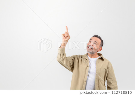 Place For Ad. Smiling senior man pointing up at copy space 112718810