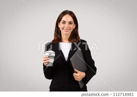 Smart and composed businesswoman holding a reusable coffee cup and digital tablet Smart and composed businesswoman holding a reusable coffee cup and digital tablet 112718981