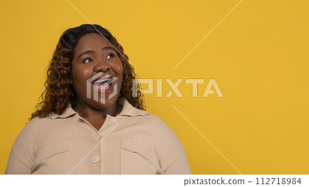 Curious chubby black woman looking at copy space 112718984