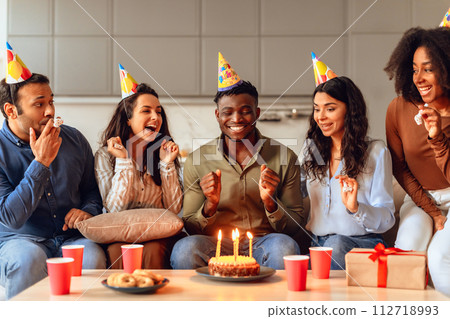 black guy making birthday wish during party with friends indoors 112718993