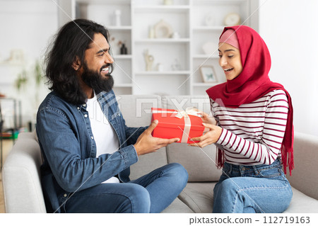 Arab man giving present to his excited muslim wife at home 112719163