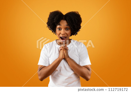 Portrait of emotional young african american woman grimacing on orange Portrait of emotional young african american woman grimacing on orange 112719172