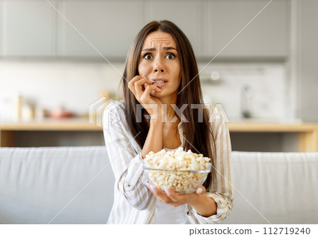 Shock Content. Scared Young Woman Watching Tv And Eating Popcorn At Home Shock Content. Scared Young Woman Watching Tv And Eating Popcorn At Home 112719240